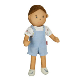 Stoffpuppe mit braunen Haaren, blauen Latzhosen, gemustertem weißen Shirt und weißen Schuhen.