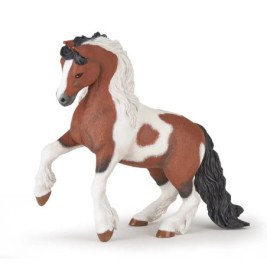 Ein braun-weißes Spielzeugpferd mit schwarzer Mähne und Schweif steht auf den Hinterbeinen.