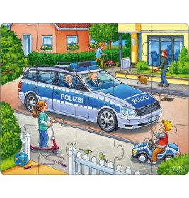 Ein Polizeiauto steht auf der Straße, während Kinder spielen und Erwachsene auf dem Gehweg laufen.