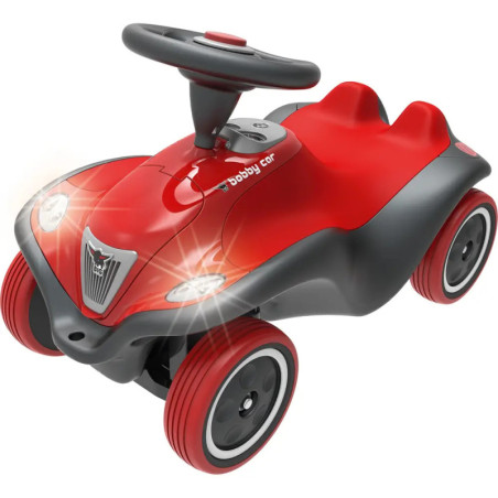 Rotes und schwarzes Kinder-Rutschauto mit leuchtenden Scheinwerfern und Lenkrad. Rotes und schwarzes Kinder-Rutschauto mit leuchtenden Scheinwerfern und Lenkrad.