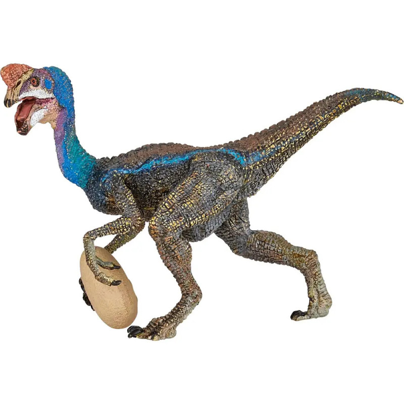 Eine Dinosaurierfigur mit blauen Markierungen hält ein Ei in einer Kralle und steht auf zwei Beinen.