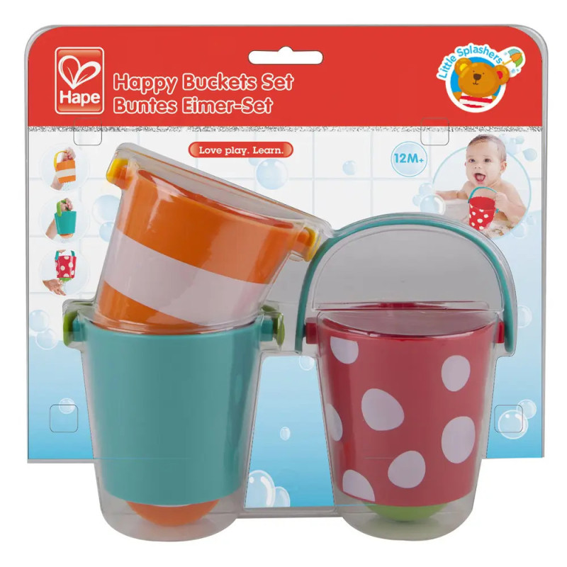 Drei bunte Spielzeugeimer im Karton, beschriftet als Happy Buckets Set für Kinder ab 12 Monaten. Drei bunte Spielzeugeimer im Karton, beschriftet als Happy Buckets Set für Kinder ab 12 Monaten.