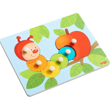 Buntes Holzpuzzle mit lachender Raupe und Apfel auf Blatt-Hintergrund, die Teile haben Knopfgriffe. Buntes Holzpuzzle mit lachender Raupe und Apfel auf Blatt-Hintergrund, die Teile haben Knopfgriffe.