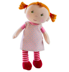 Stoffpuppe mit orangefarbenen Zöpfen, rosa gemustertem Kleid, gestreiften Leggings und roten Schuhen.