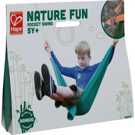 Ein Junge schaukelt in einer grünen Tasche Verpackung: Nature Fun Pocket Swing, 5+, aus Bambus. Ein Junge schaukelt in einer grünen Tasche Verpackung: Nature Fun Pocket Swing, 5+, aus Bambus.