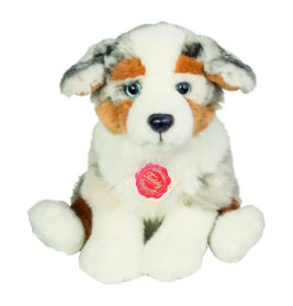 Plüschhund mit weißem, braunem und grauem Fell sitzt aufrecht, Brust trägt ein Etikett.