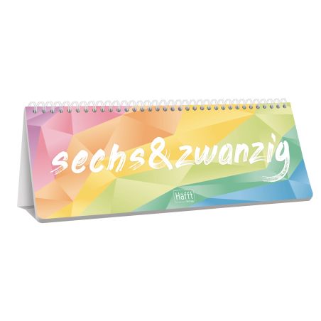 Bunter Tischkalender mit "sechs&zwanzig" in weißer Schrift auf geometrischem Regenbogen-Hintergrund.