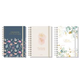 Drei spiralgebundene Planer mit floralen Kappen in Blau, Weiß und Pastell stehen aufrecht nebeneinander.