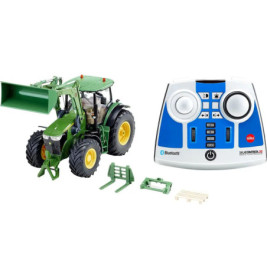Grüner Spielzeugtraktor mit Frontlader, Zubehör und blau-weißer Fernbedienung mit Knöpfen und Drehreglern.